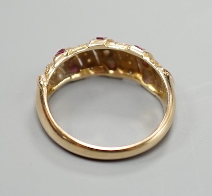 A modern 585 yellow metal, ruby and diamond chip set half hoop ring, size M/N, gross weight 3.3 grams.